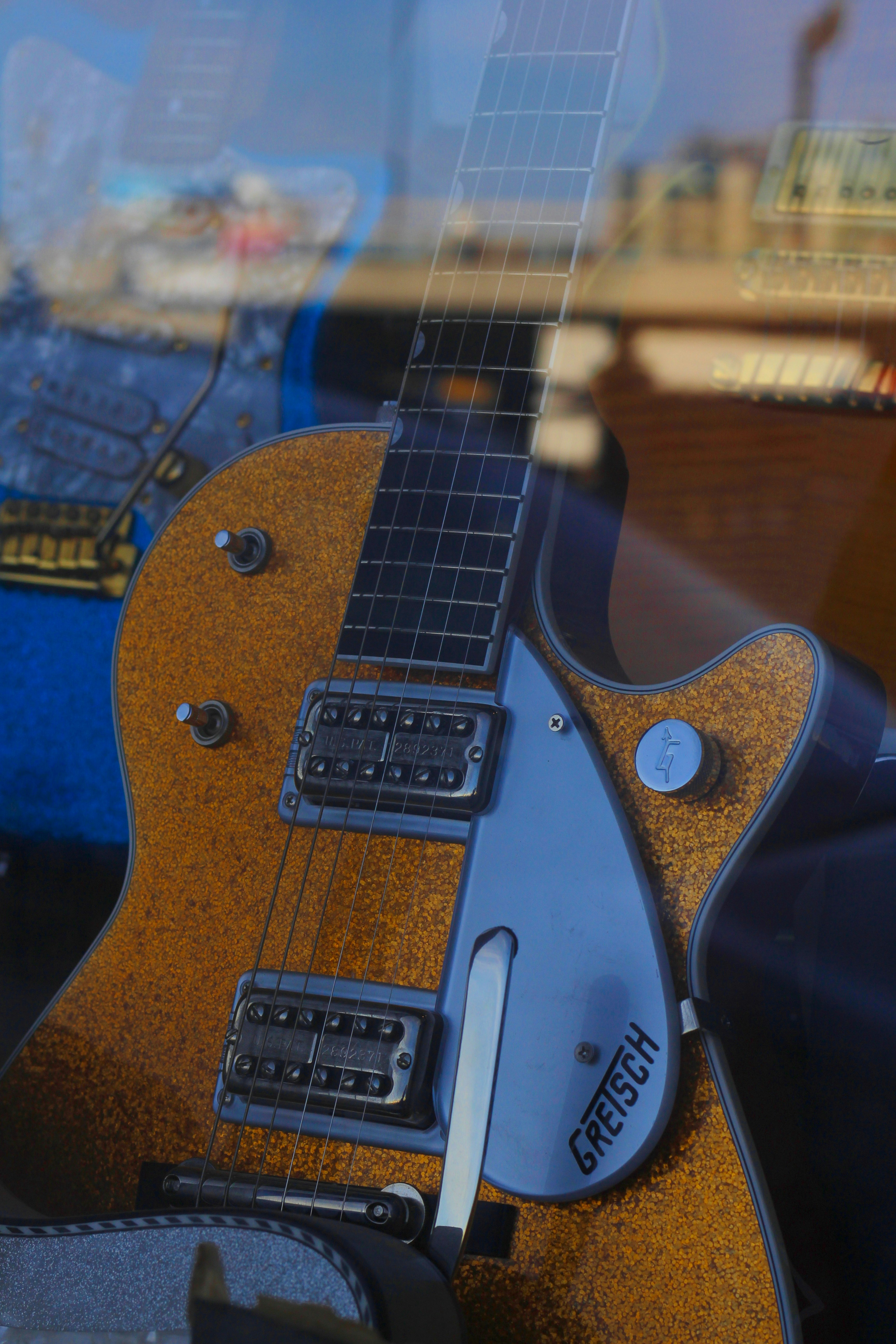 A guitar sitting on a stand in front of a window
