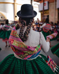A woman in a black hat and green skirt