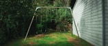 A swing set in a yard next to a house