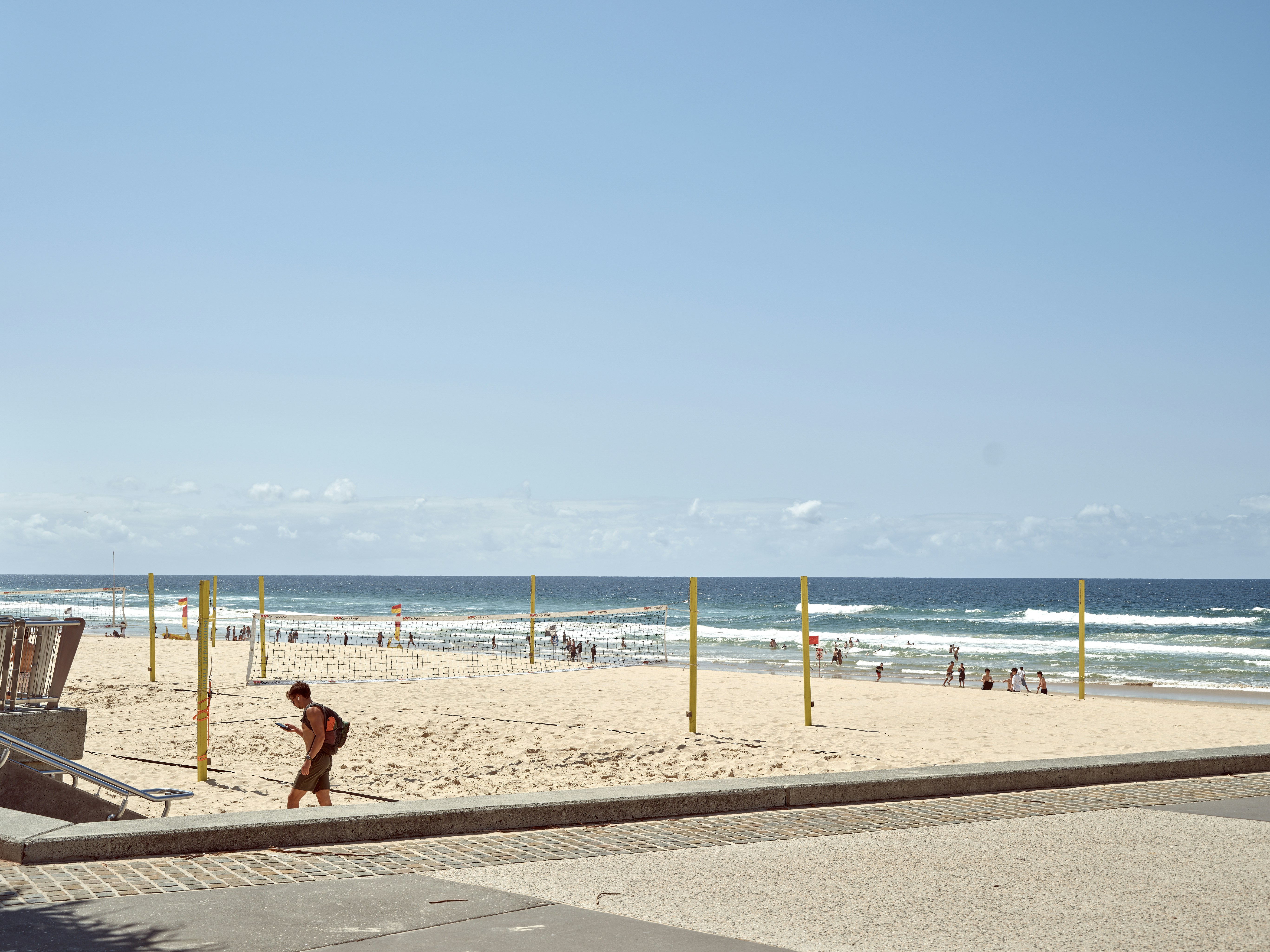 A man walking on a beach next to the ocean