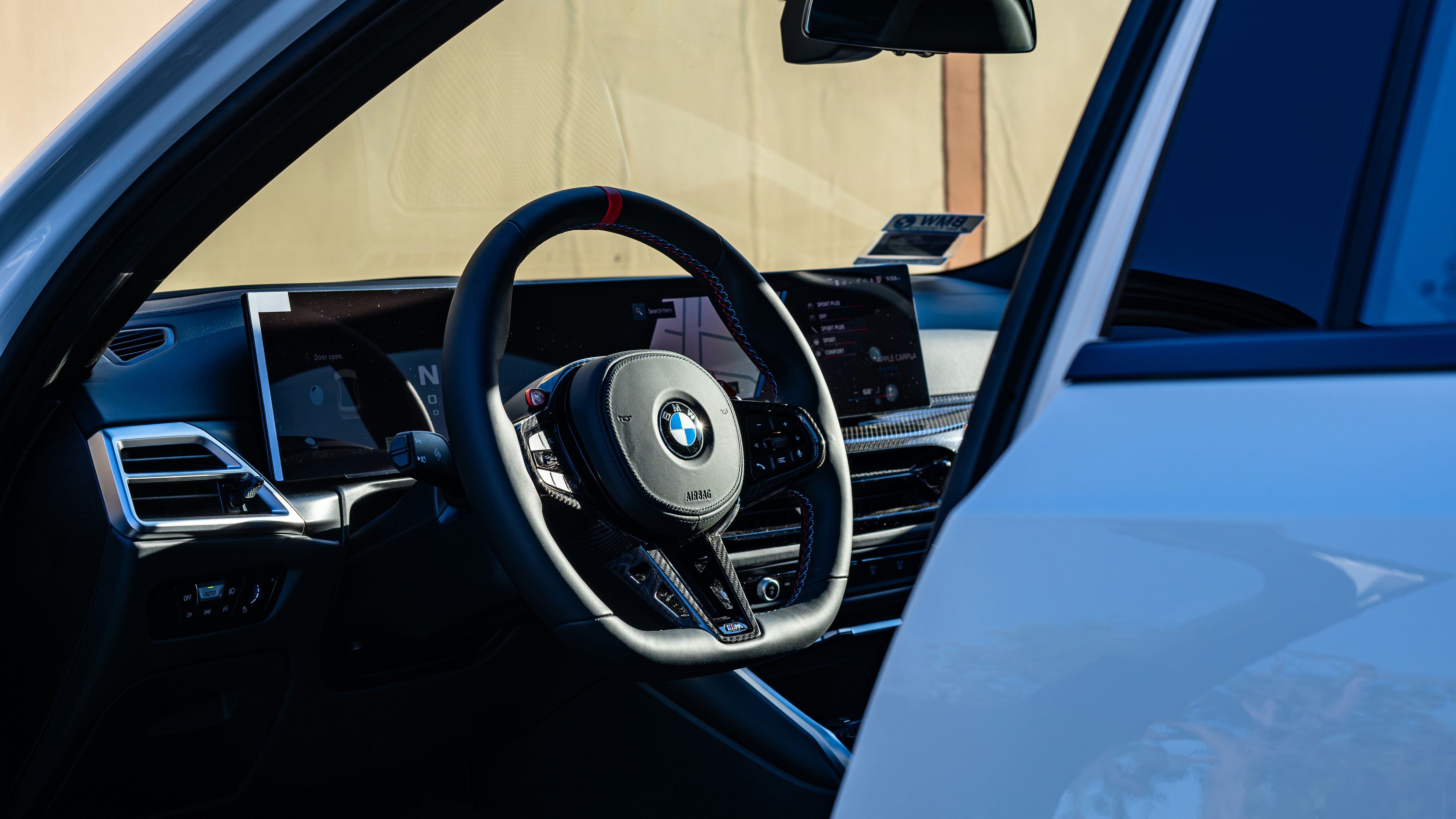 The interior of a car with a steering wheel and dashboard