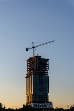 A tall building with a crane on top of it