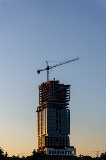 A tall building with a crane on top of it