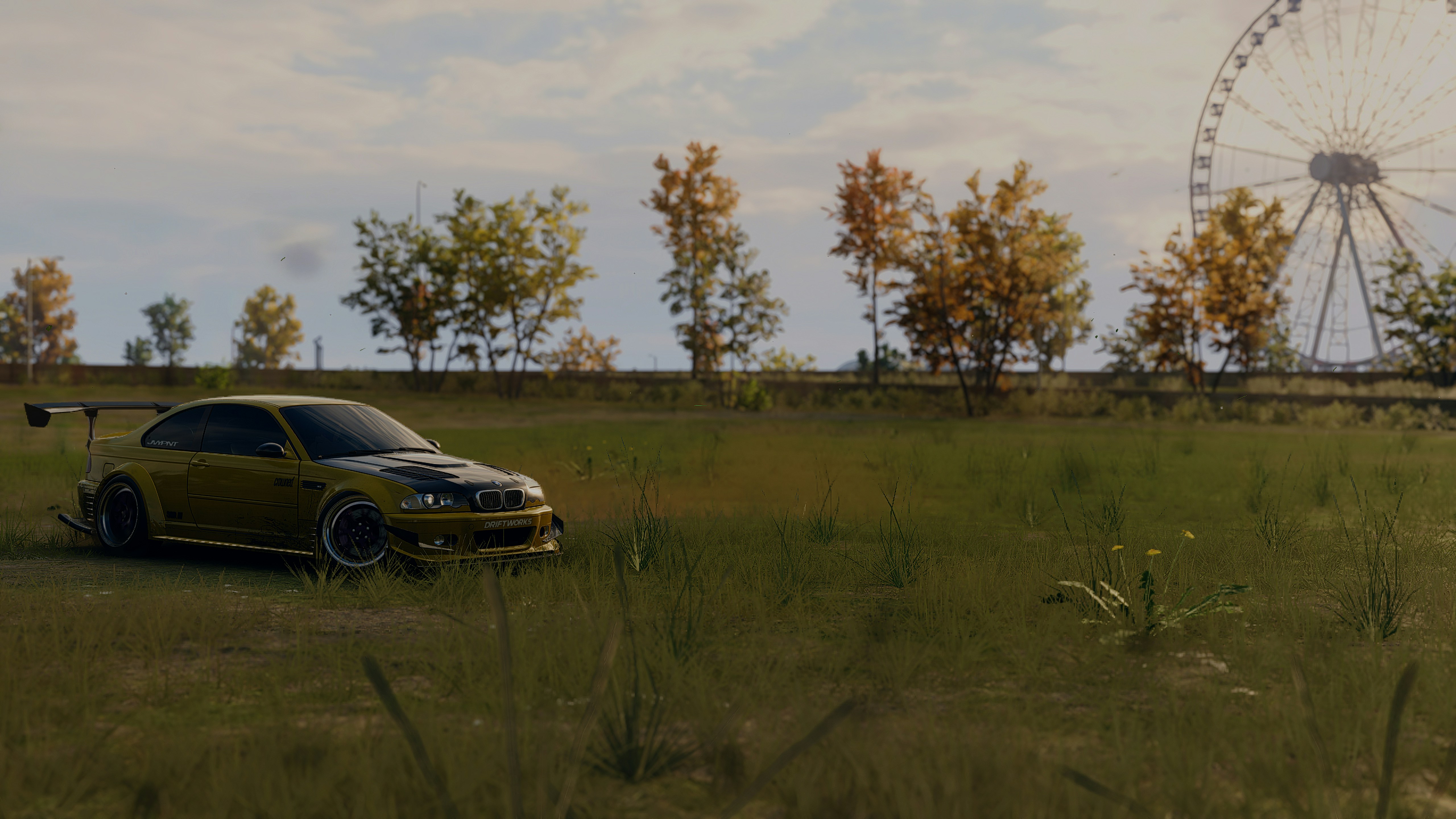 A car parked in a field next to a ferris wheel