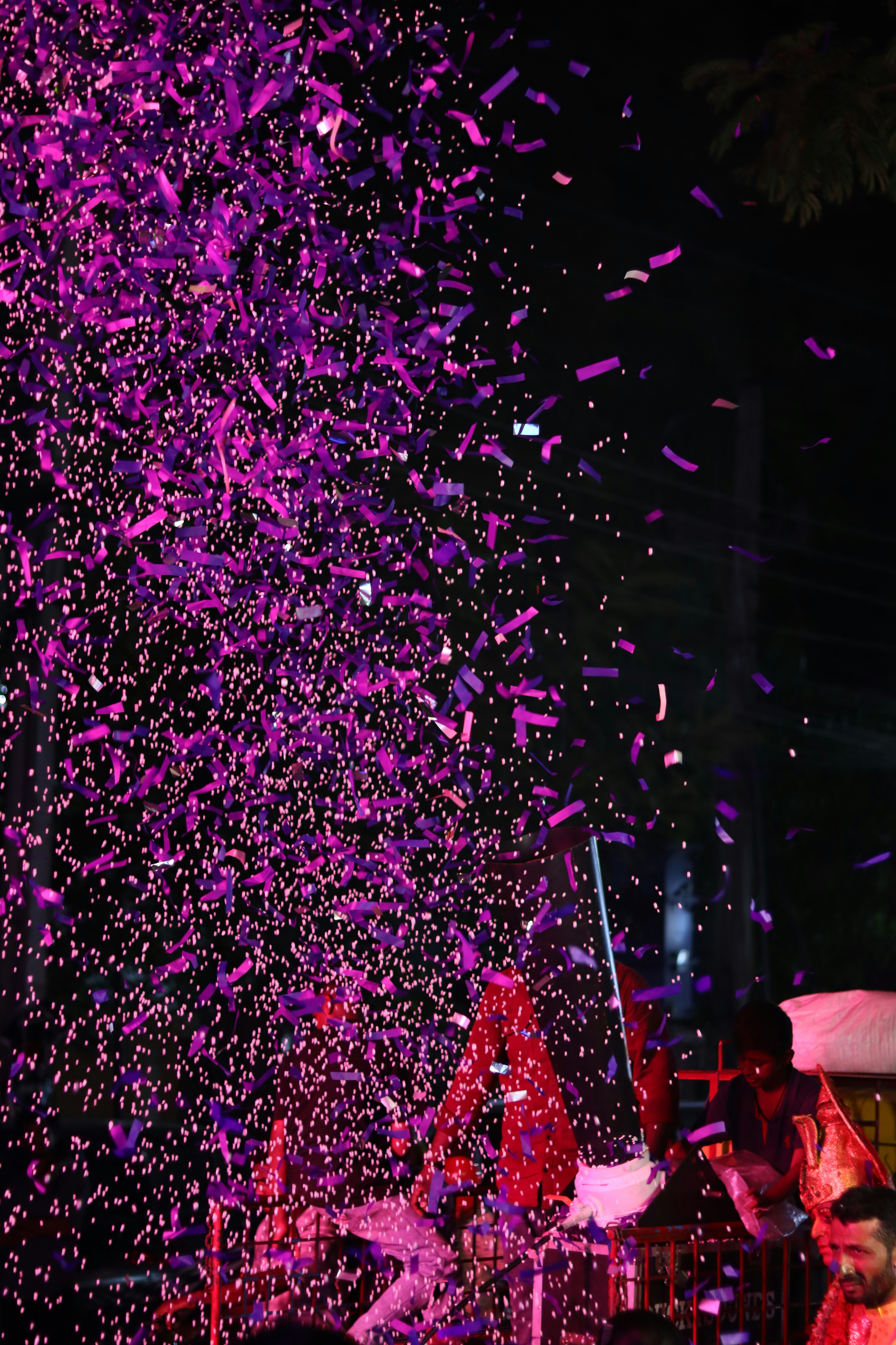A crowd of people standing around a stage covered in confetti