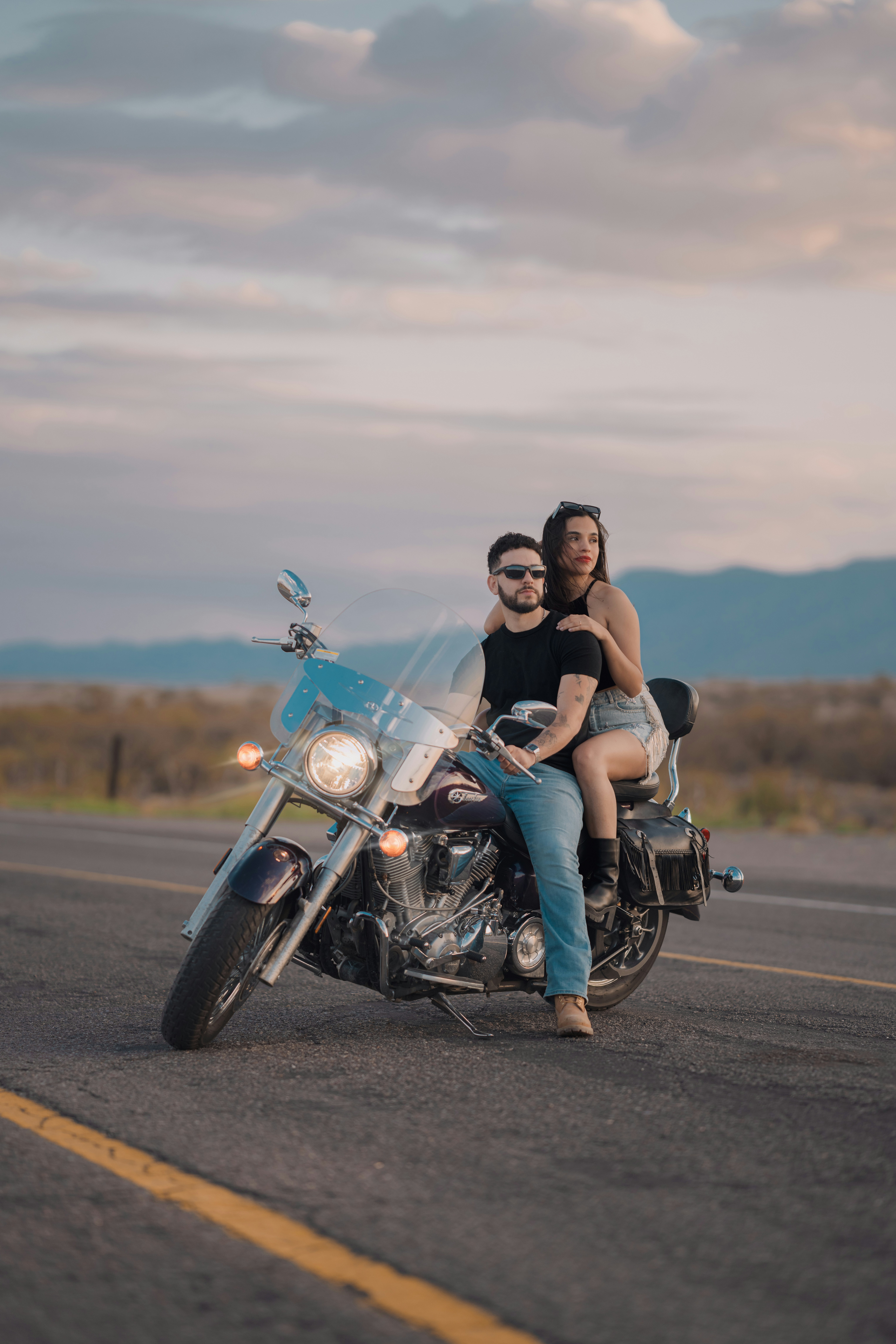 A man and woman riding on the back of a motorcycle