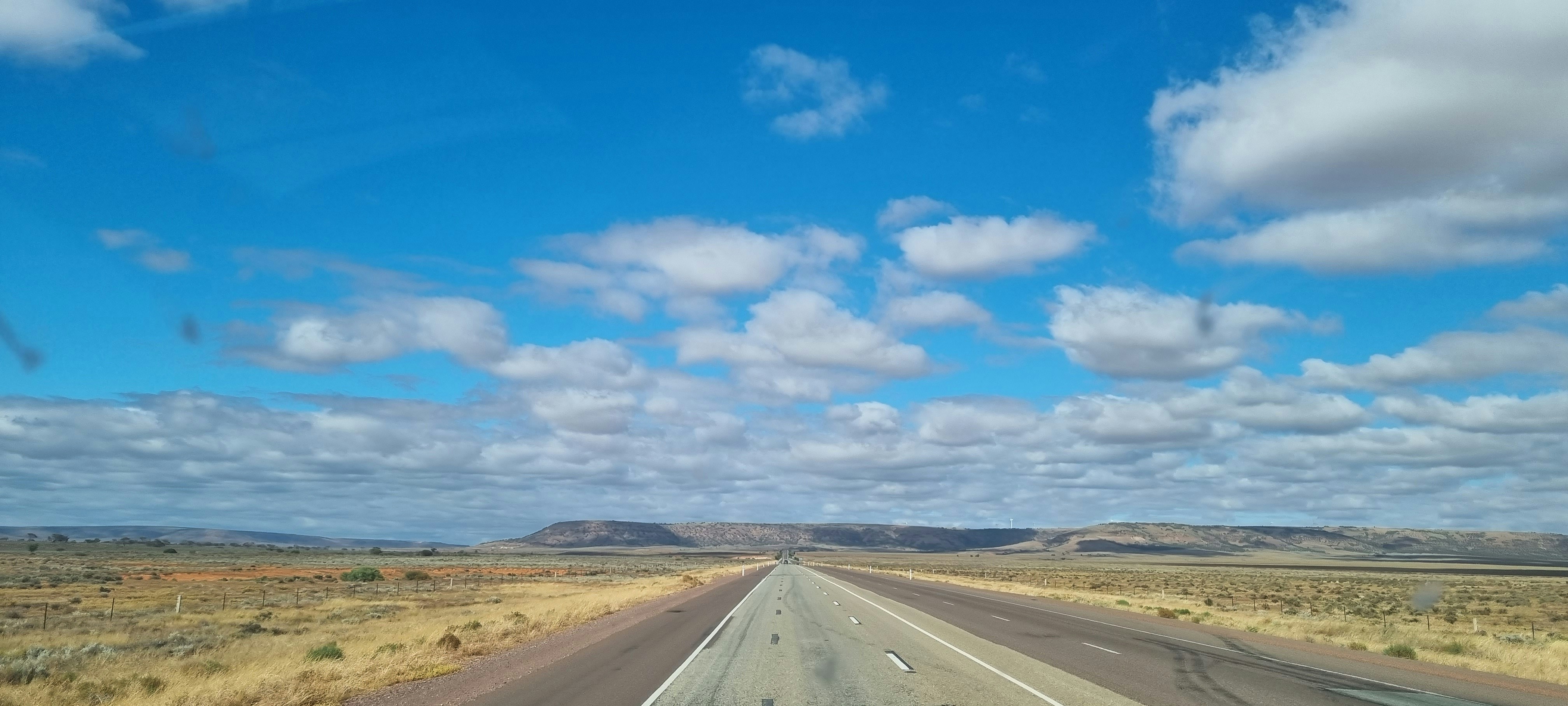 A car driving down a highway with a sky background