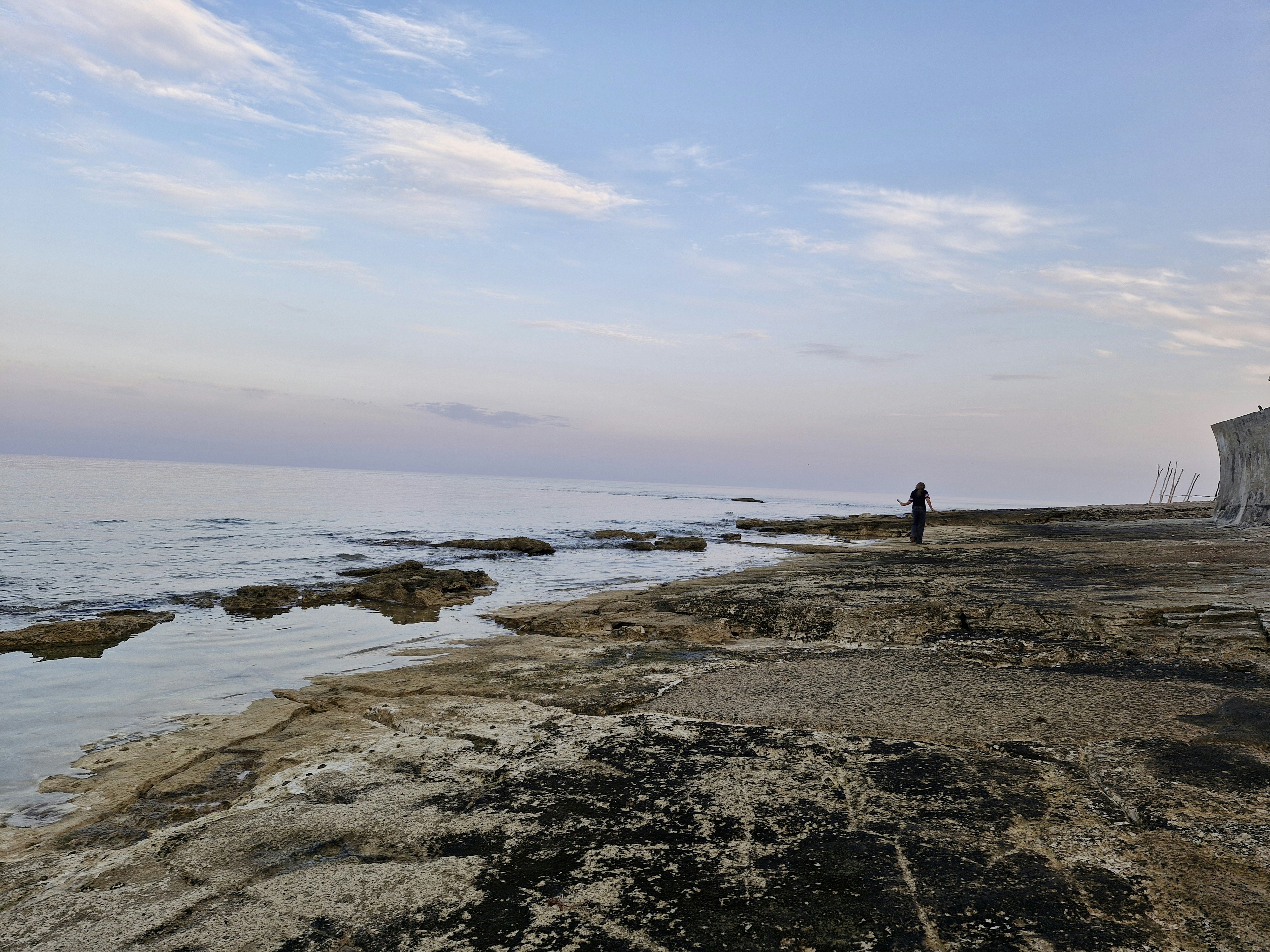 A man standing on a beach next to the ocean