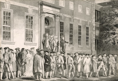 Men gather outside a grand building with classical architecture.