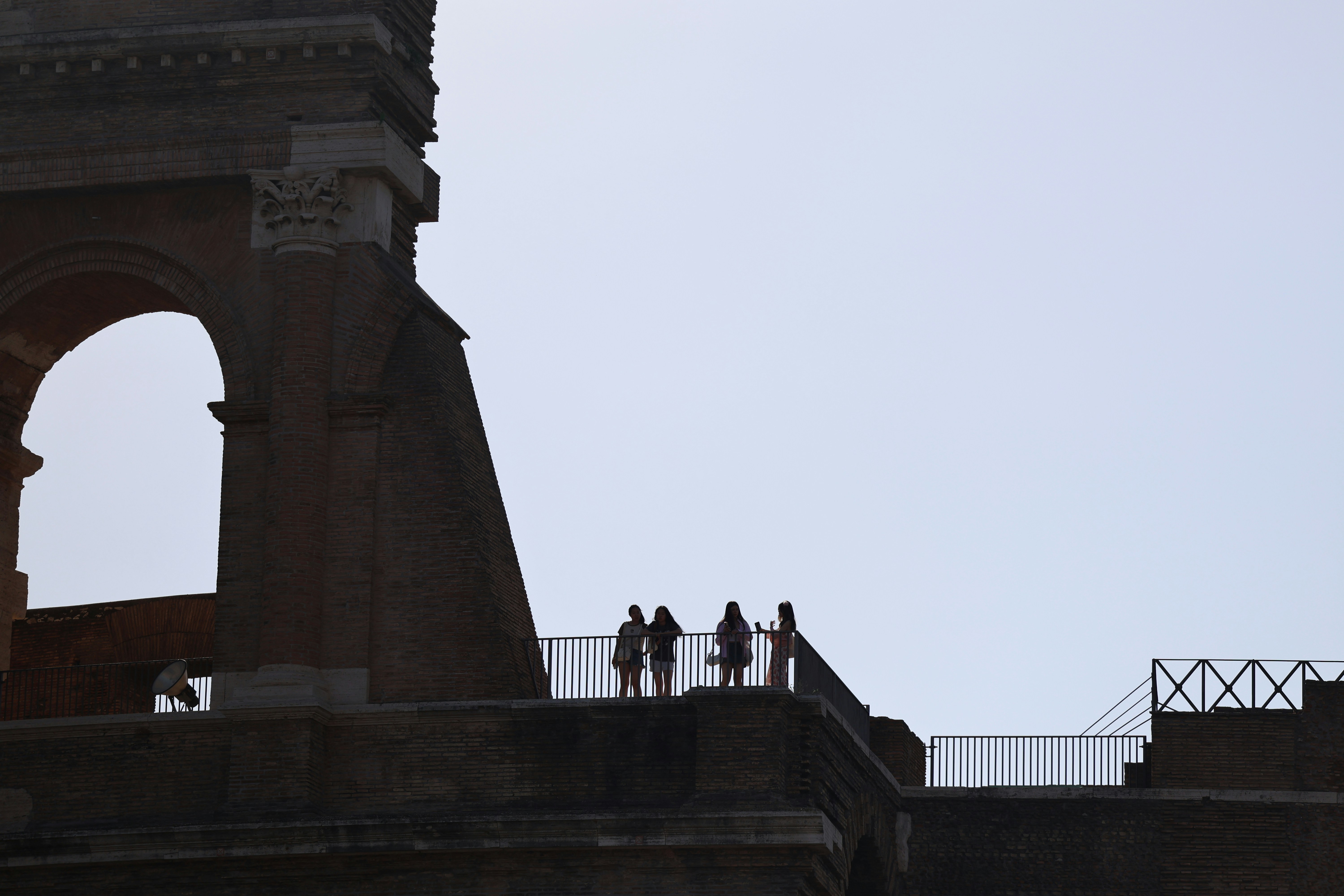 A group of people standing on top of a bridge, 