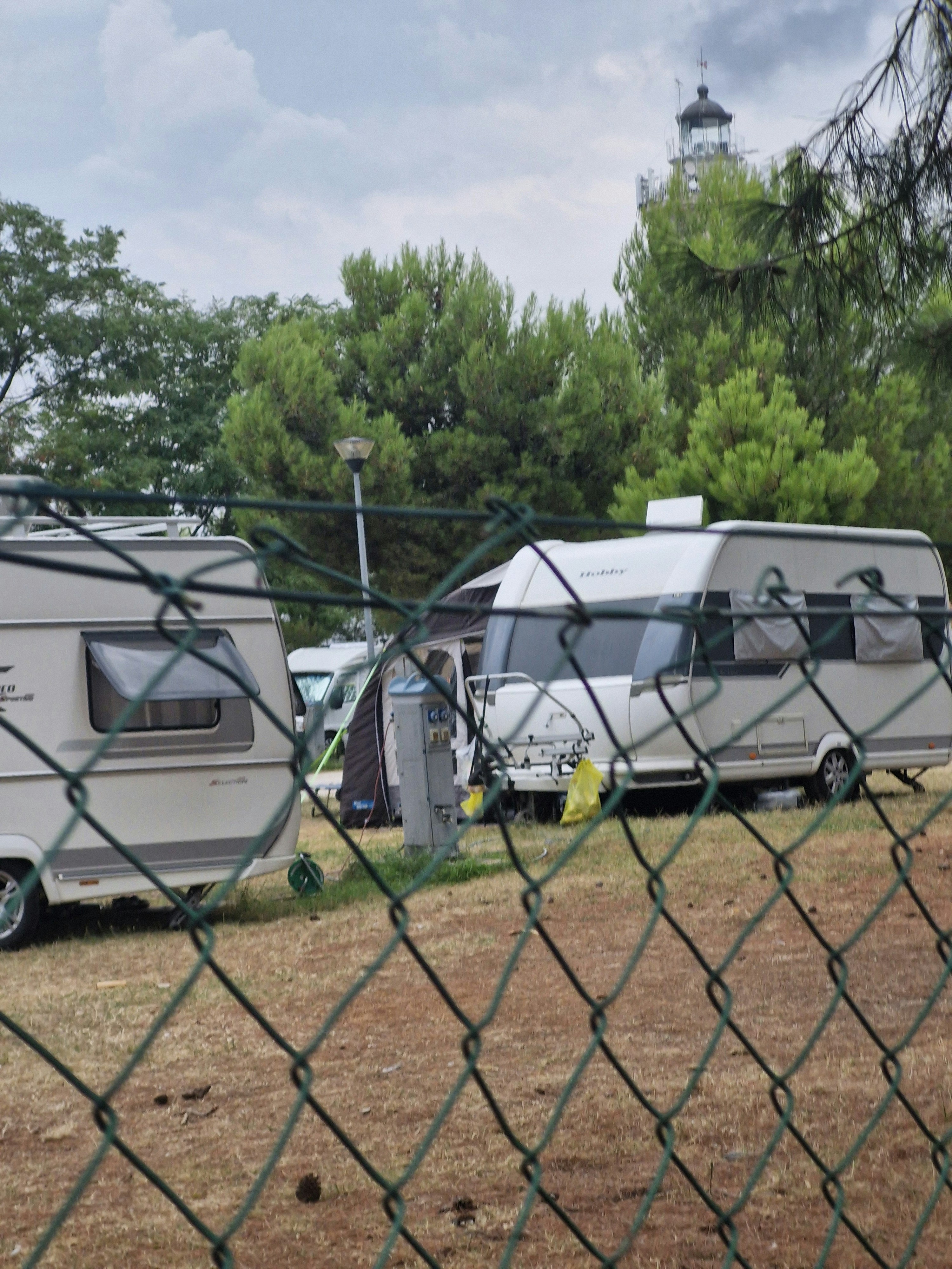A couple of rvs parked next to each other behind a chain link fence