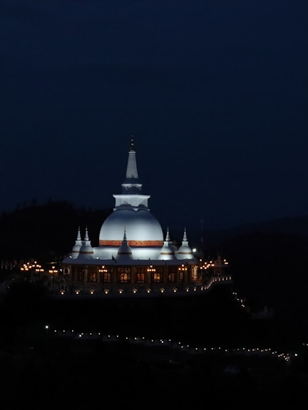 A building lit up at night with a sky background