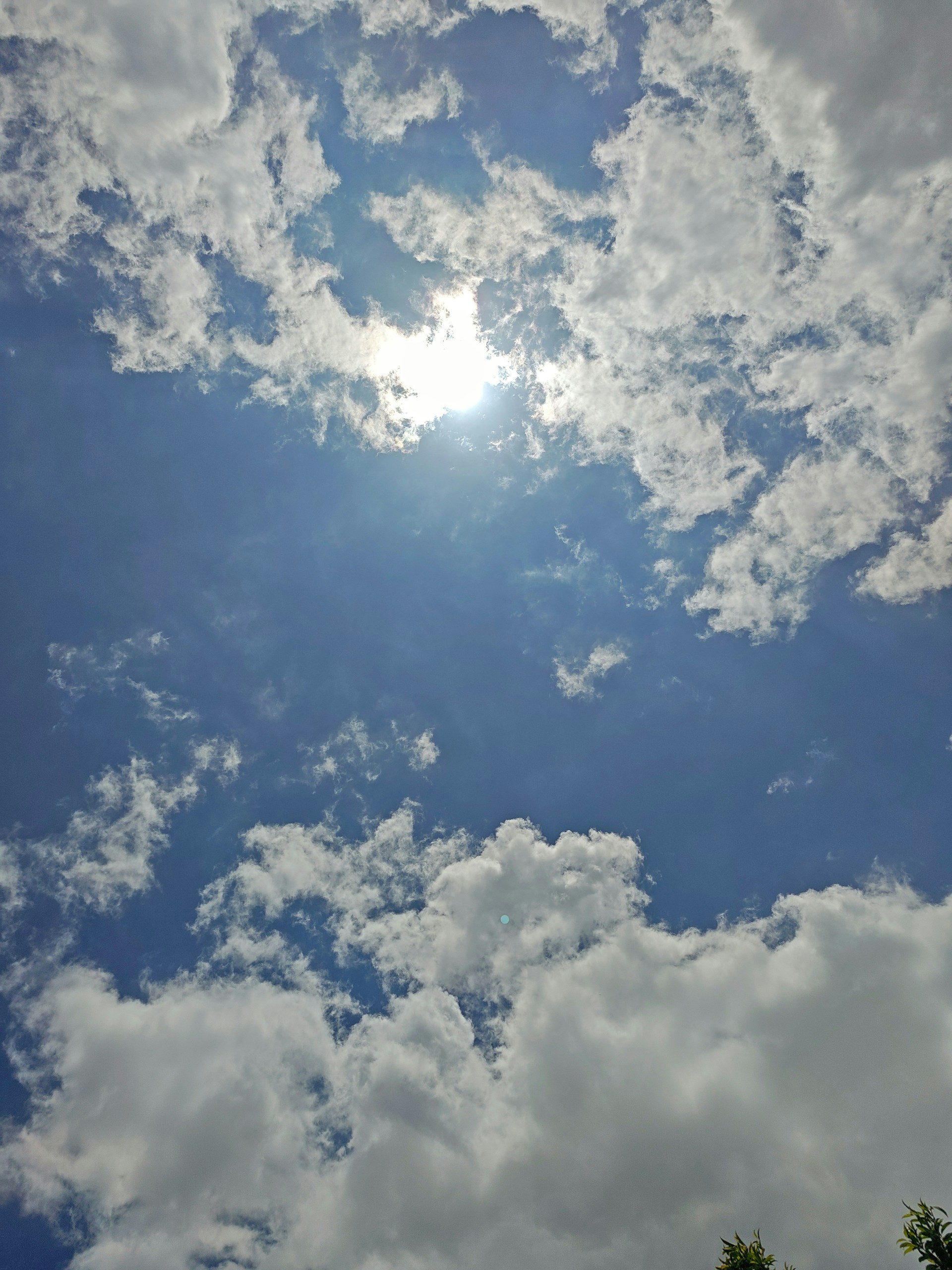 The sun is shining through the clouds in the sky