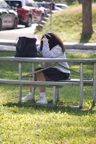 A woman sitting on a bench in a park