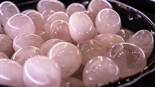A bowl filled with lots of white hearts on top of a table