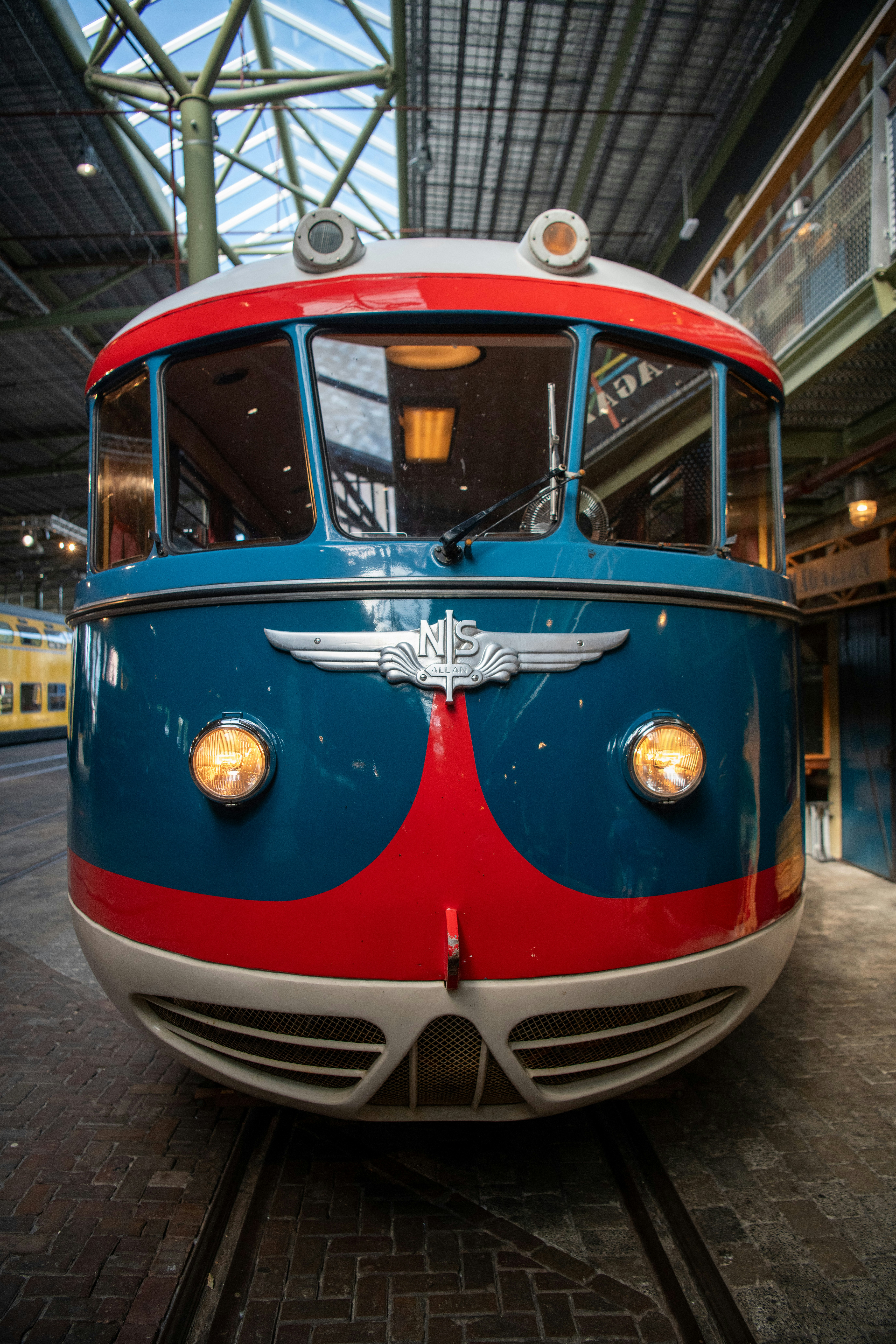A red, white and blue train is on the tracks