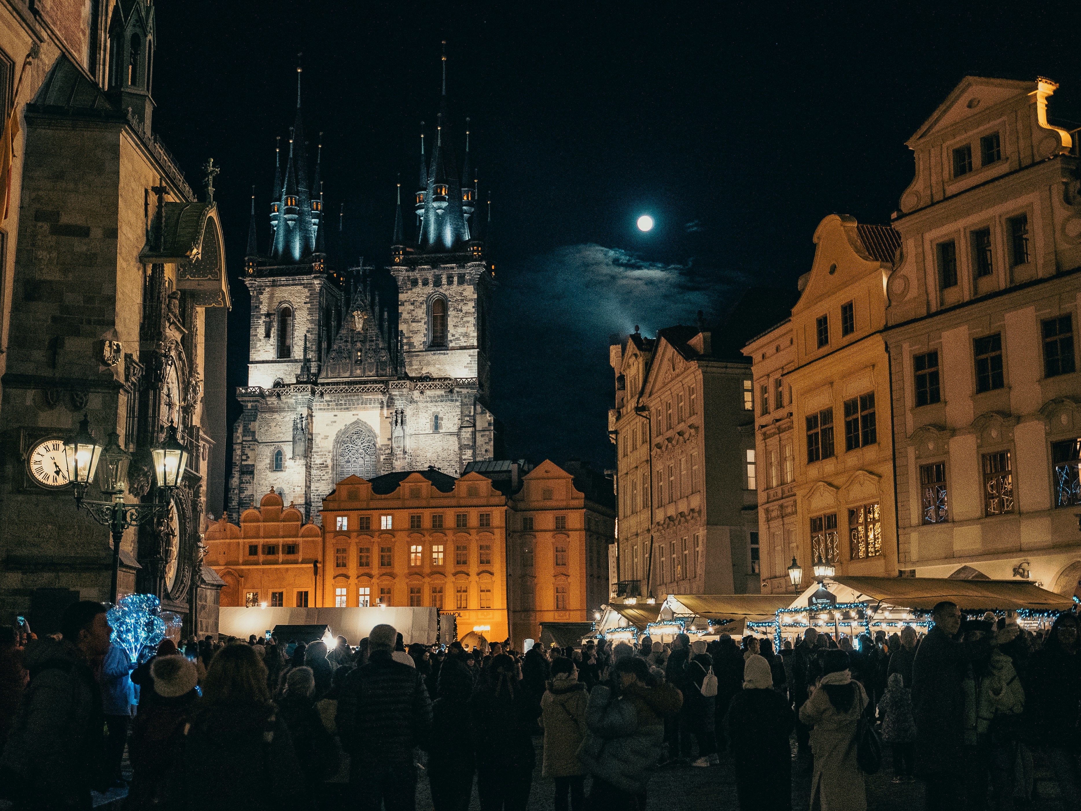 A crowd of people standing around a city at night