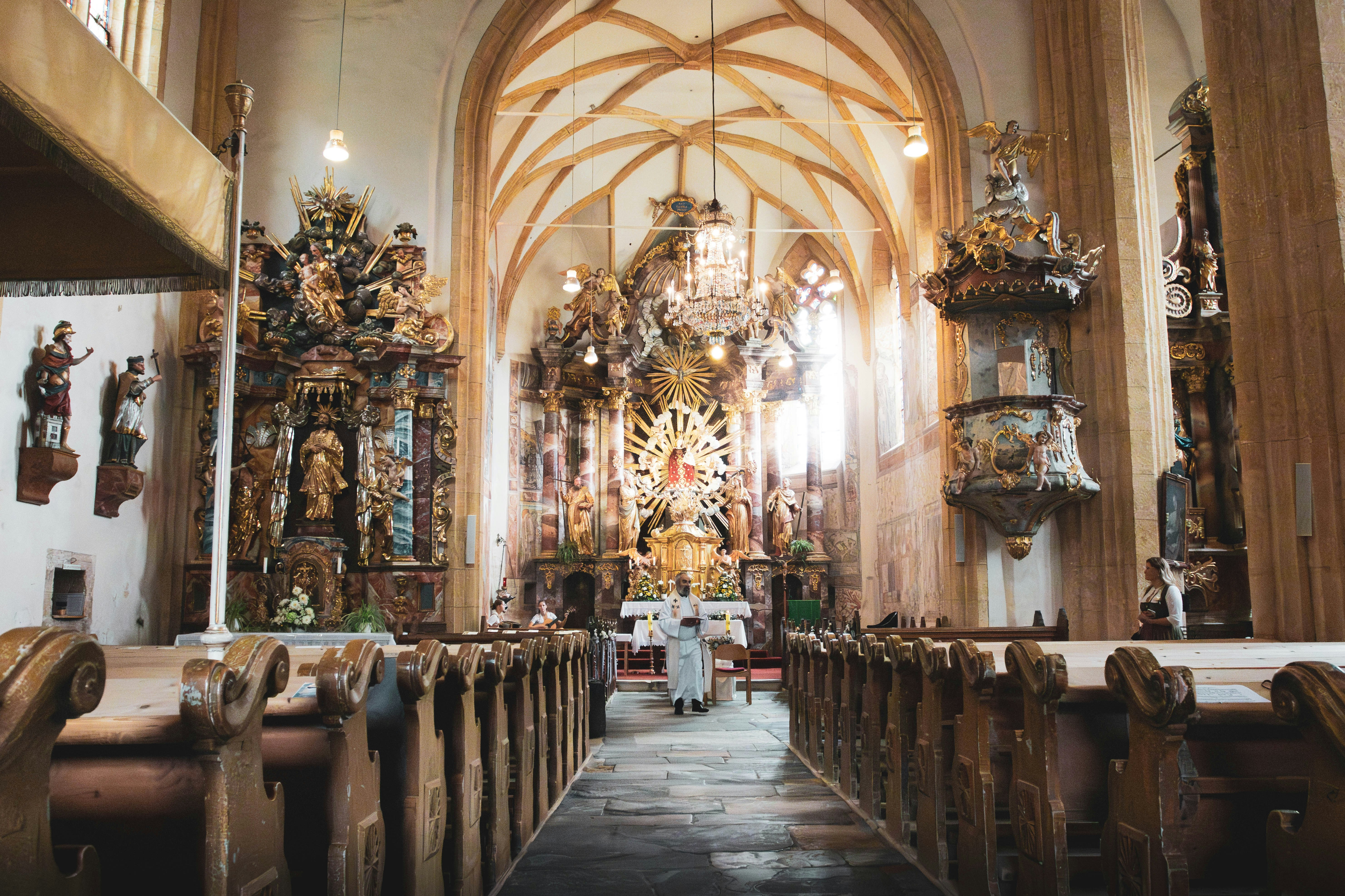 L’intérieur d’une église avec des bancs et un lustre