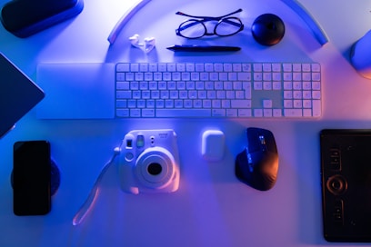 A desk with a keyboard, mouse, and other items