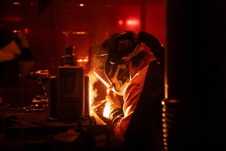 A man is welding in a dark room