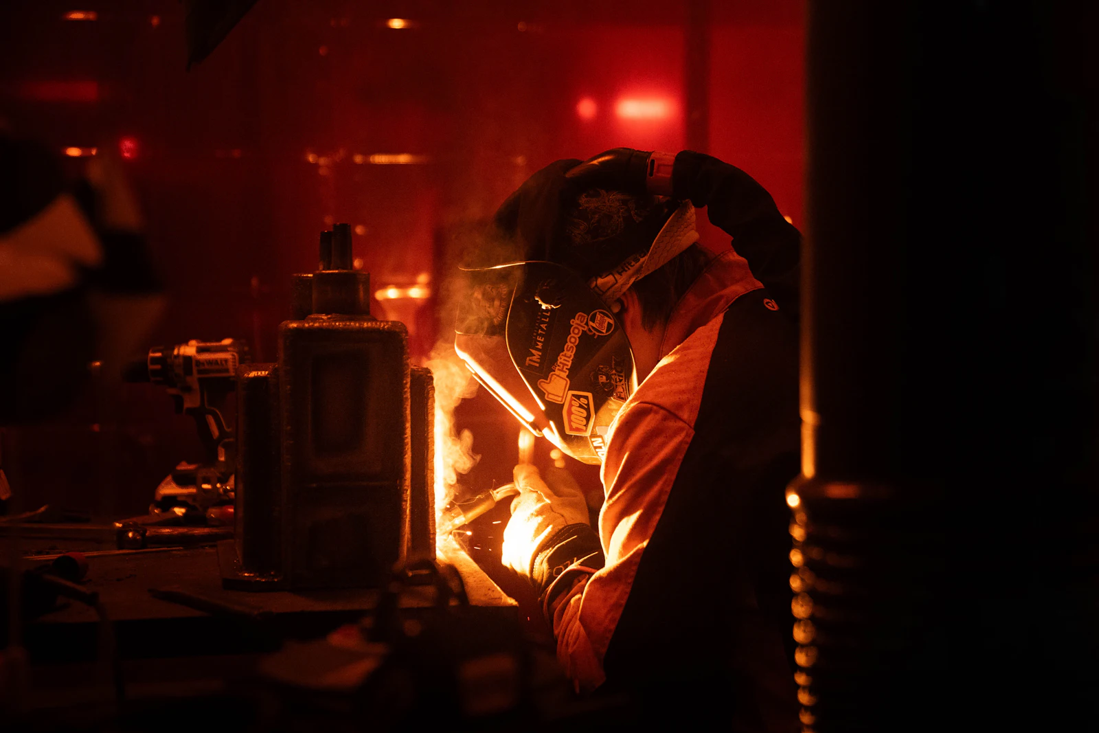 Soldador trabajando sobre una pieza metálica industrial
