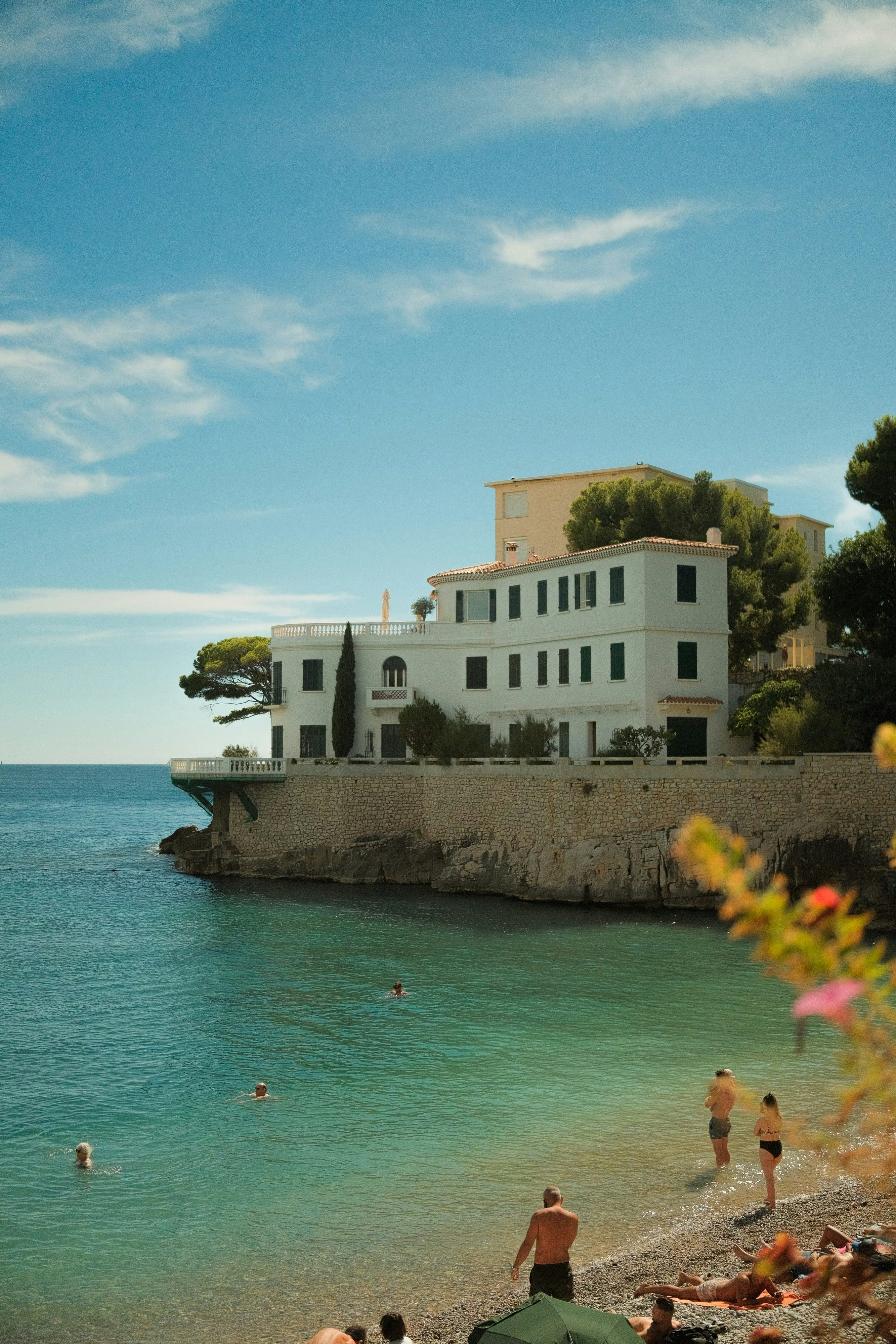 French Riviera luxury estate on cliff edge, Mediterranean Sea, afternoon haze, white stone villa, deep blue water, atmospheric