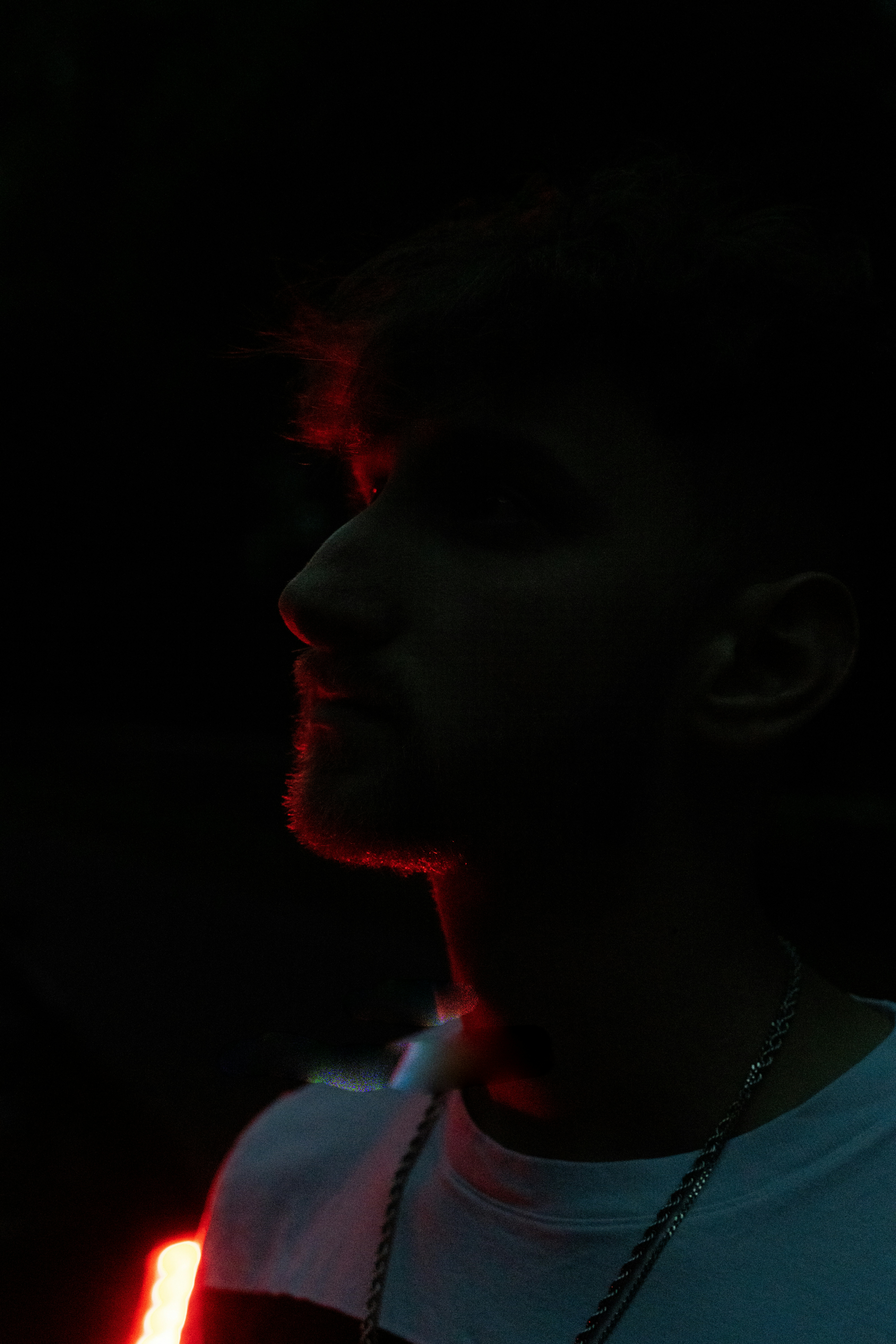 A man in a white shirt is holding a cell phone