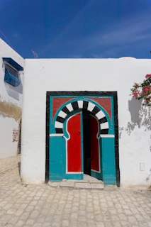 A white building with a red and blue door