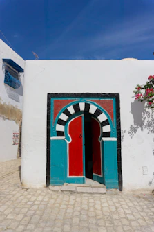A white building with a red and blue door