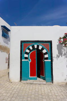 A white building with a red and blue door