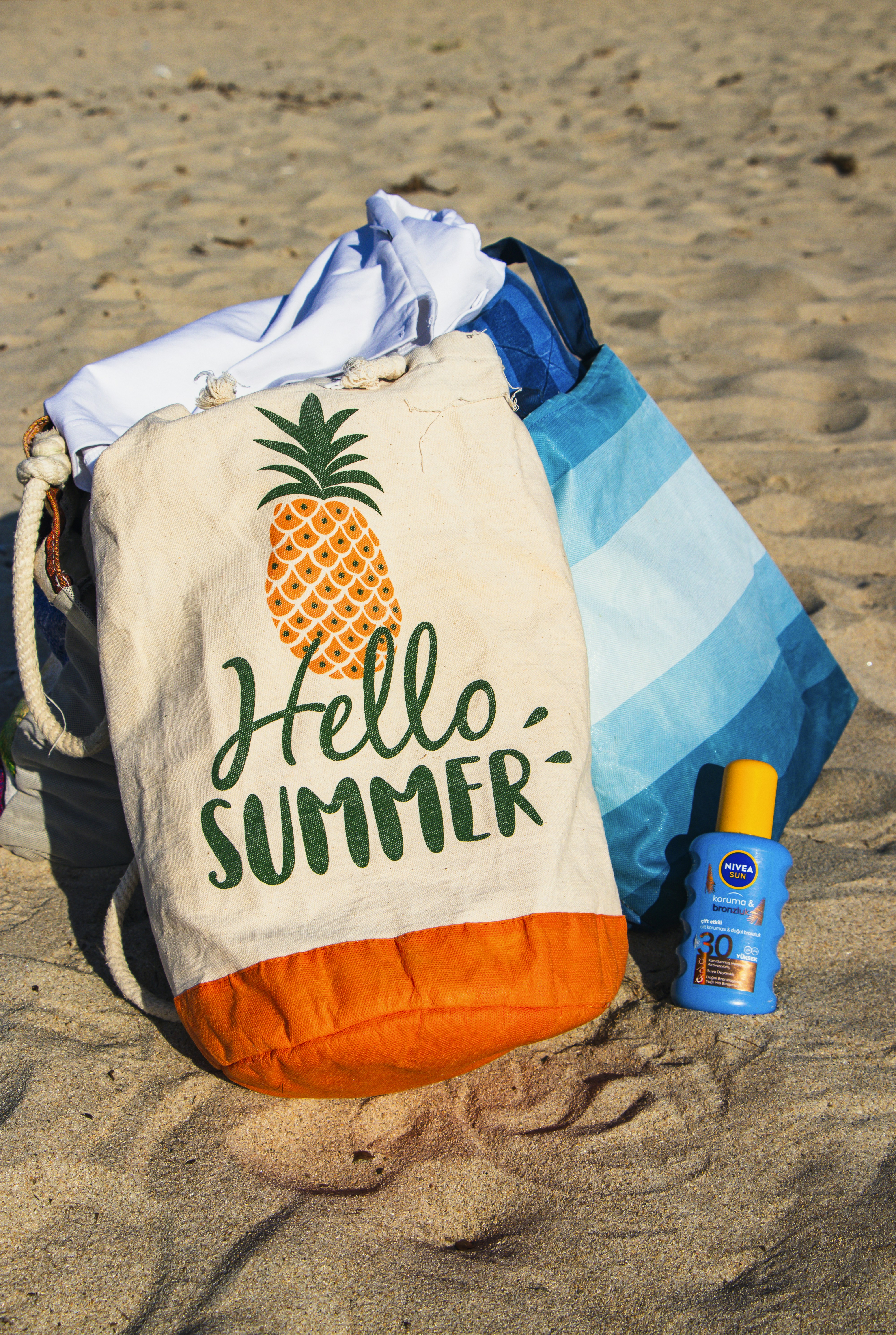 A tote bag sitting on top of a sandy beach