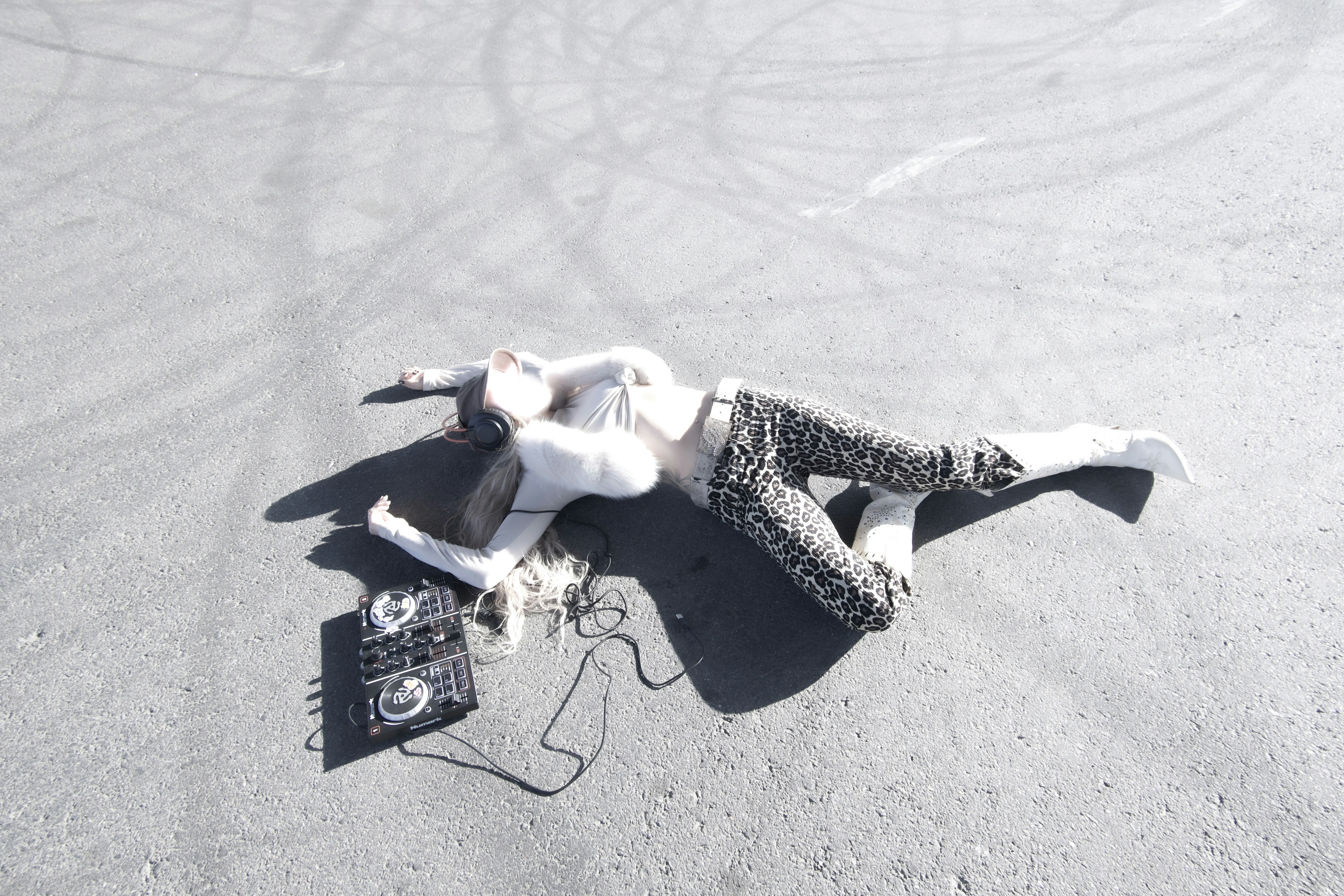A woman laying on the ground with a cell phone