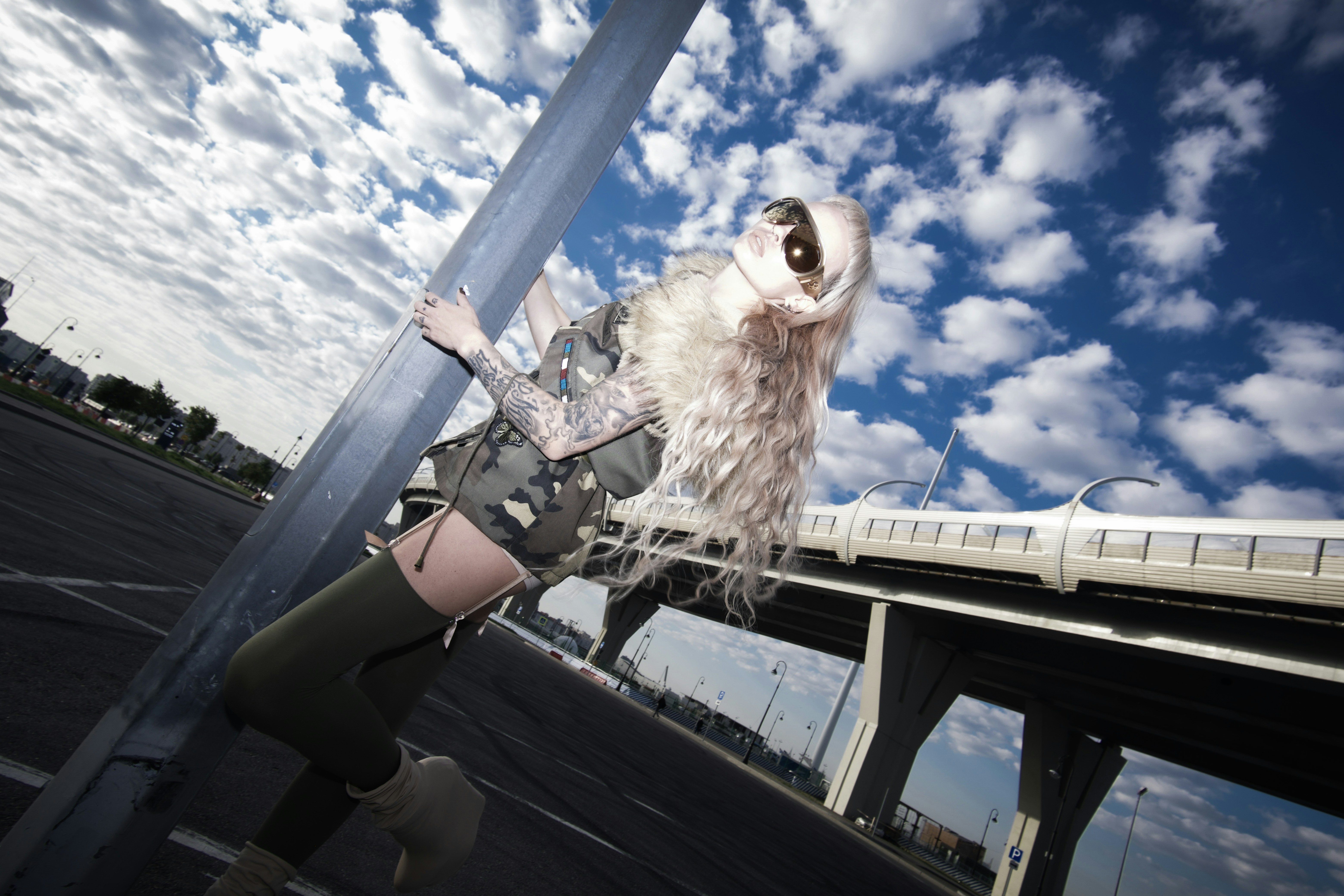 A person holding a skateboard on top of a bridge