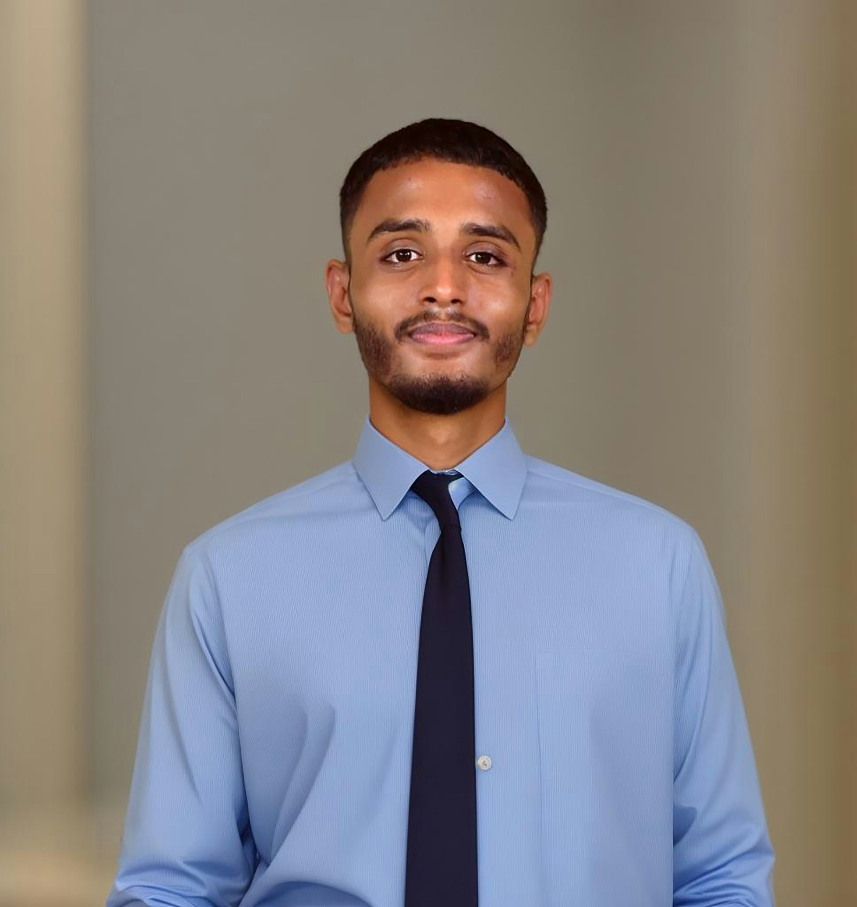 Young man with confident smile, neutral background