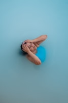 A woman is floating in a blue pool