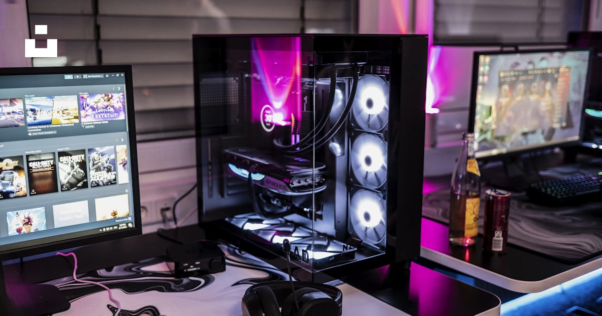 A man sitting at a desk with three computer monitors photo – Free ...