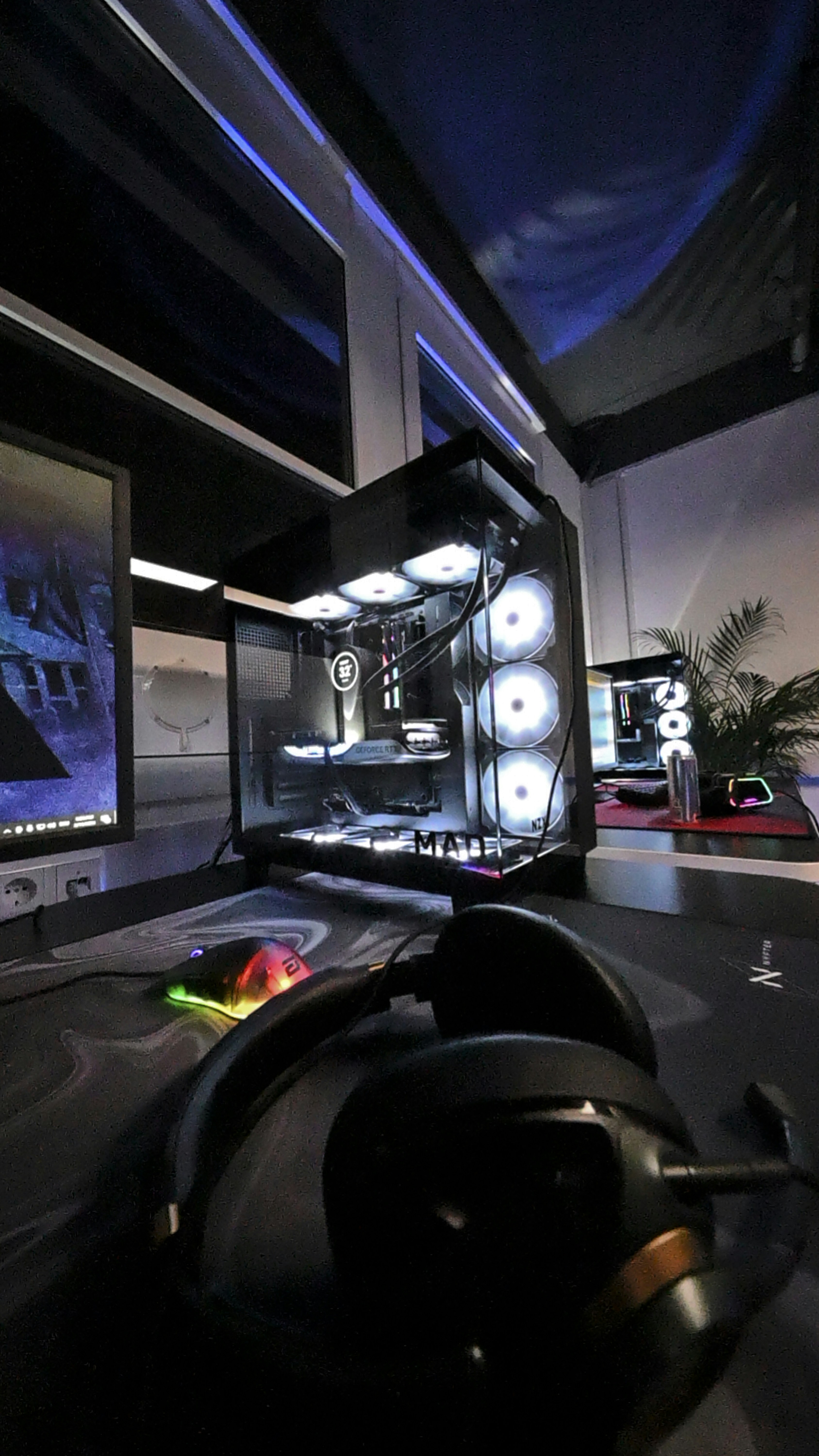 A gaming room with a large monitor and a mouse