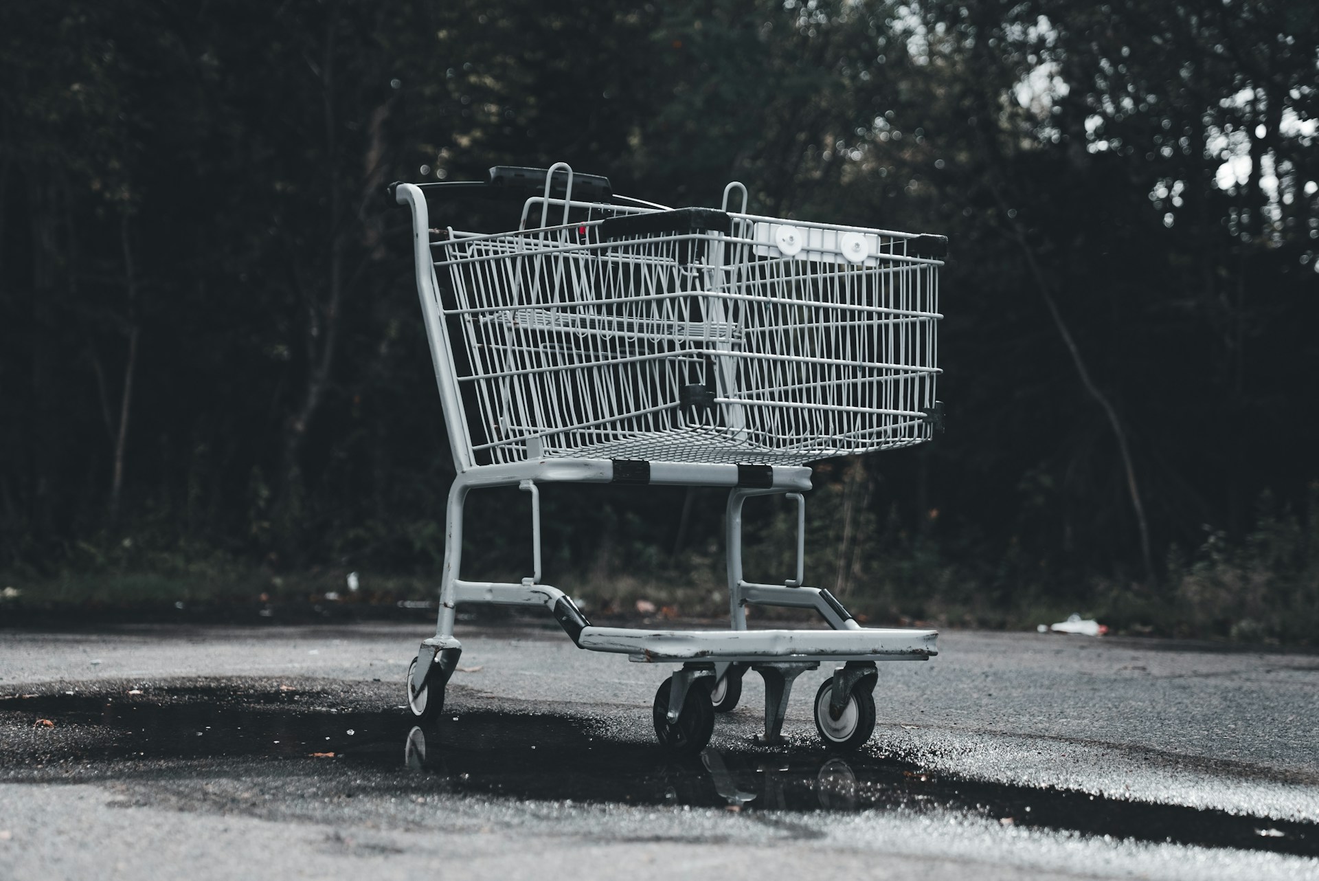 A shopping cart sitting on the side of a road