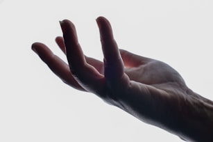 A person's hand reaching up into the sky
