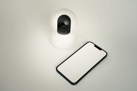 A camera and a cell phone sitting on a table