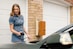 A woman is standing next to a car