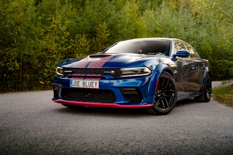 A blue car parked on the side of a road