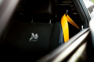 The interior of a car with a black and yellow seat belt