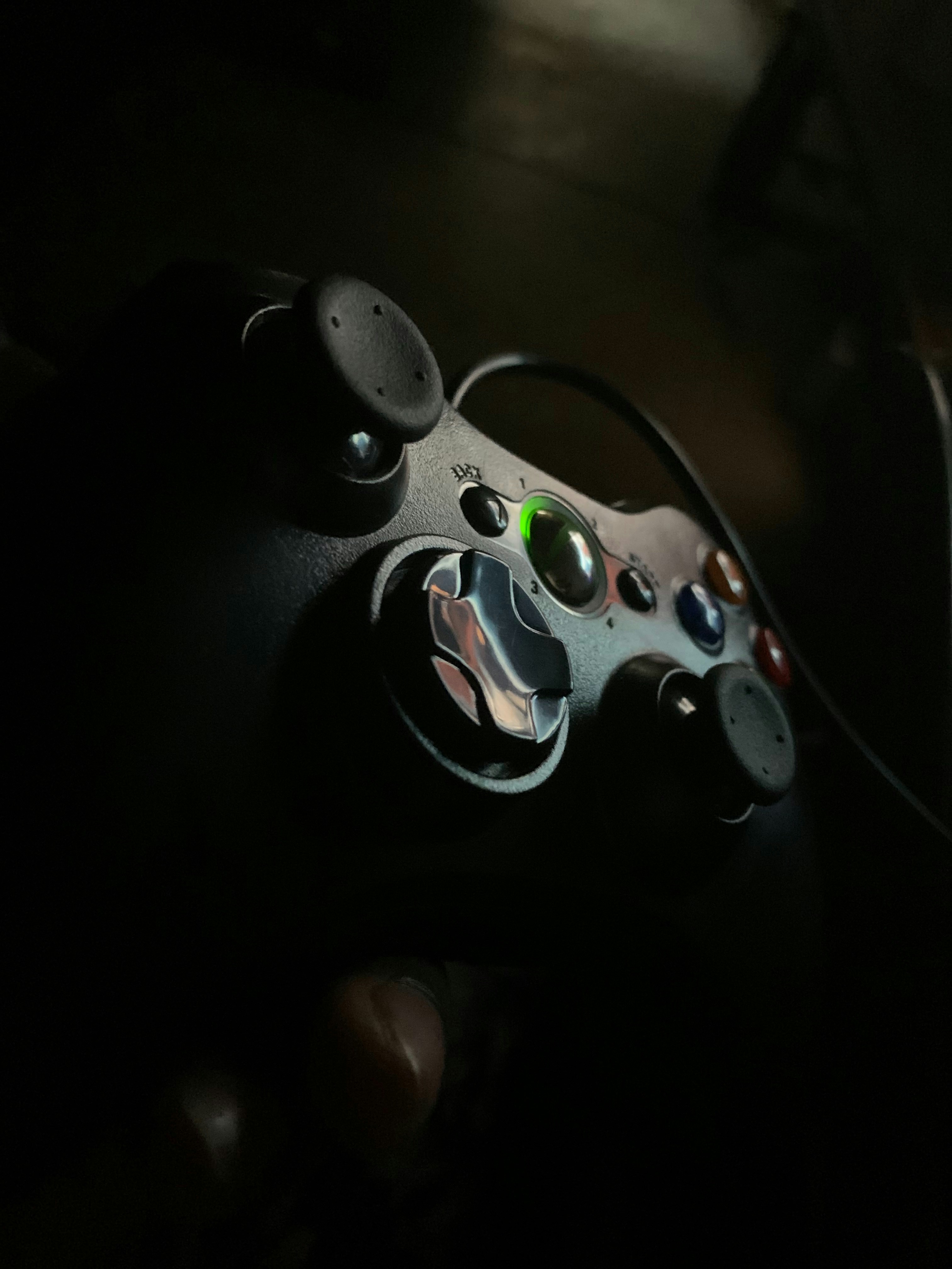 Xbox controller glowing green with gaming setup in dark ambient lighting