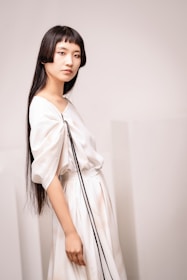 A woman in a white dress holding a black purse