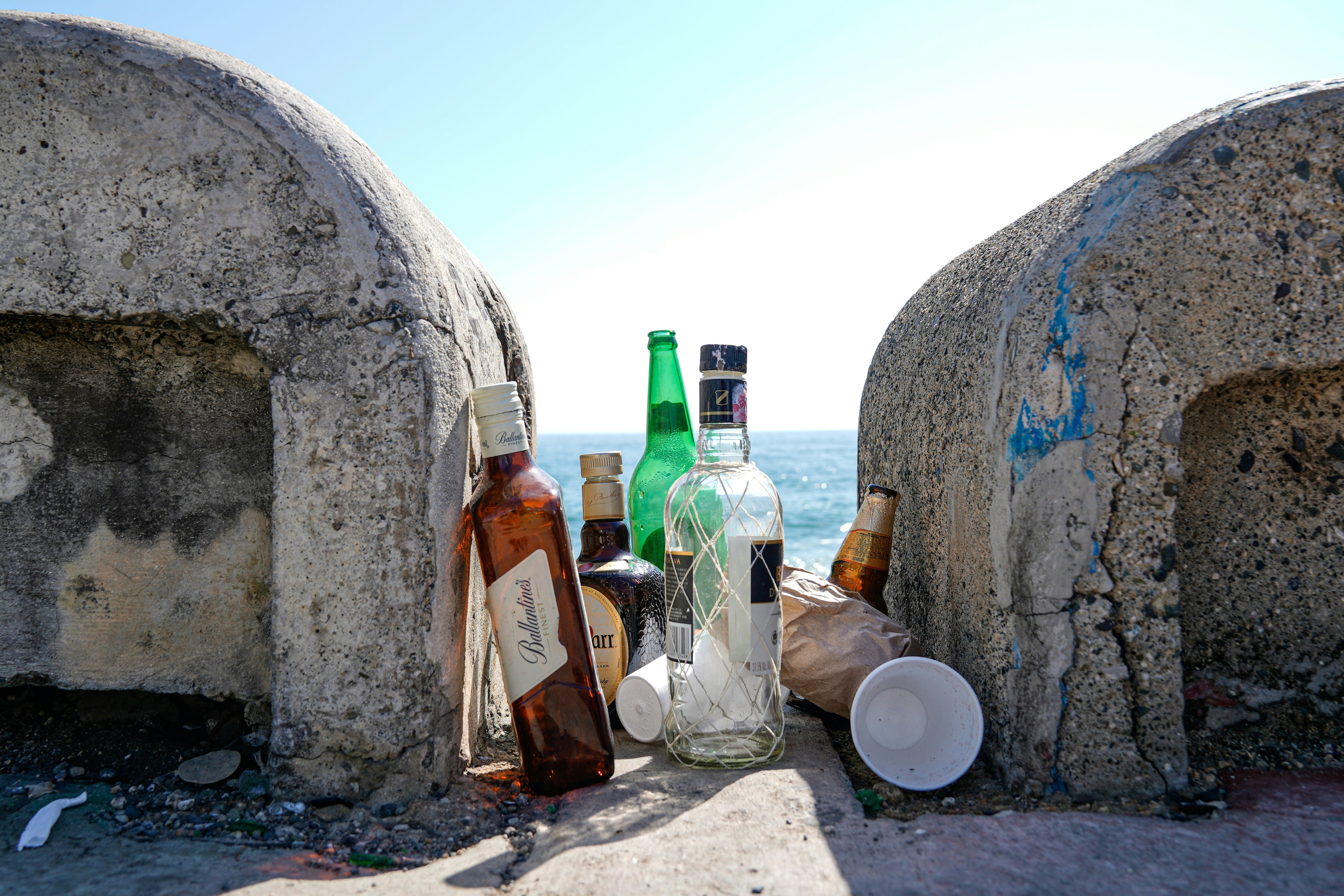 A group of bottles sitting on top of a cement wall