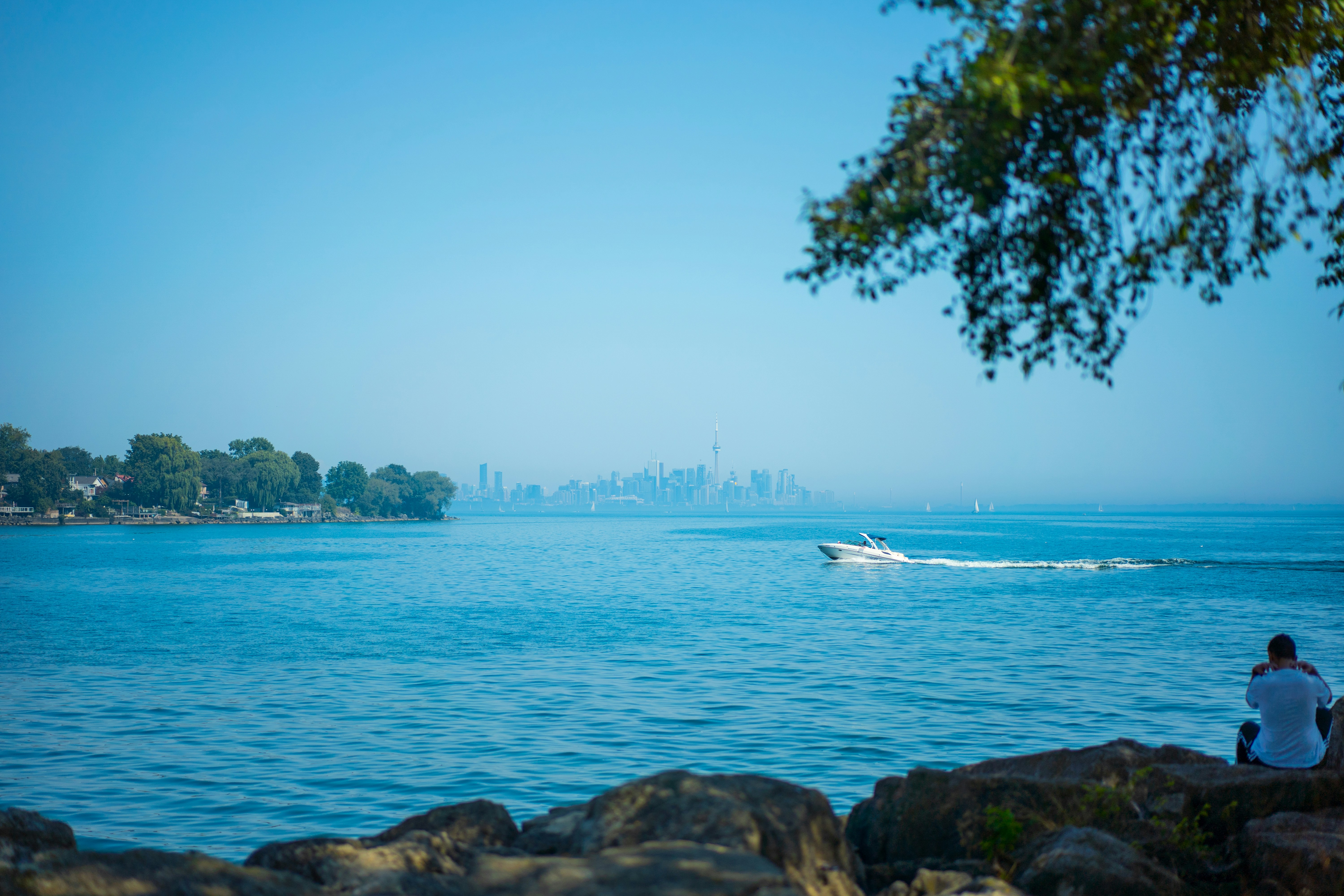 바위 위에 앉아 물을 바라보고 있는 남자