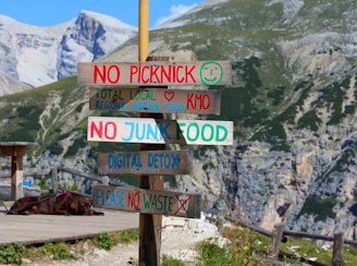A wooden sign with many different signs on it