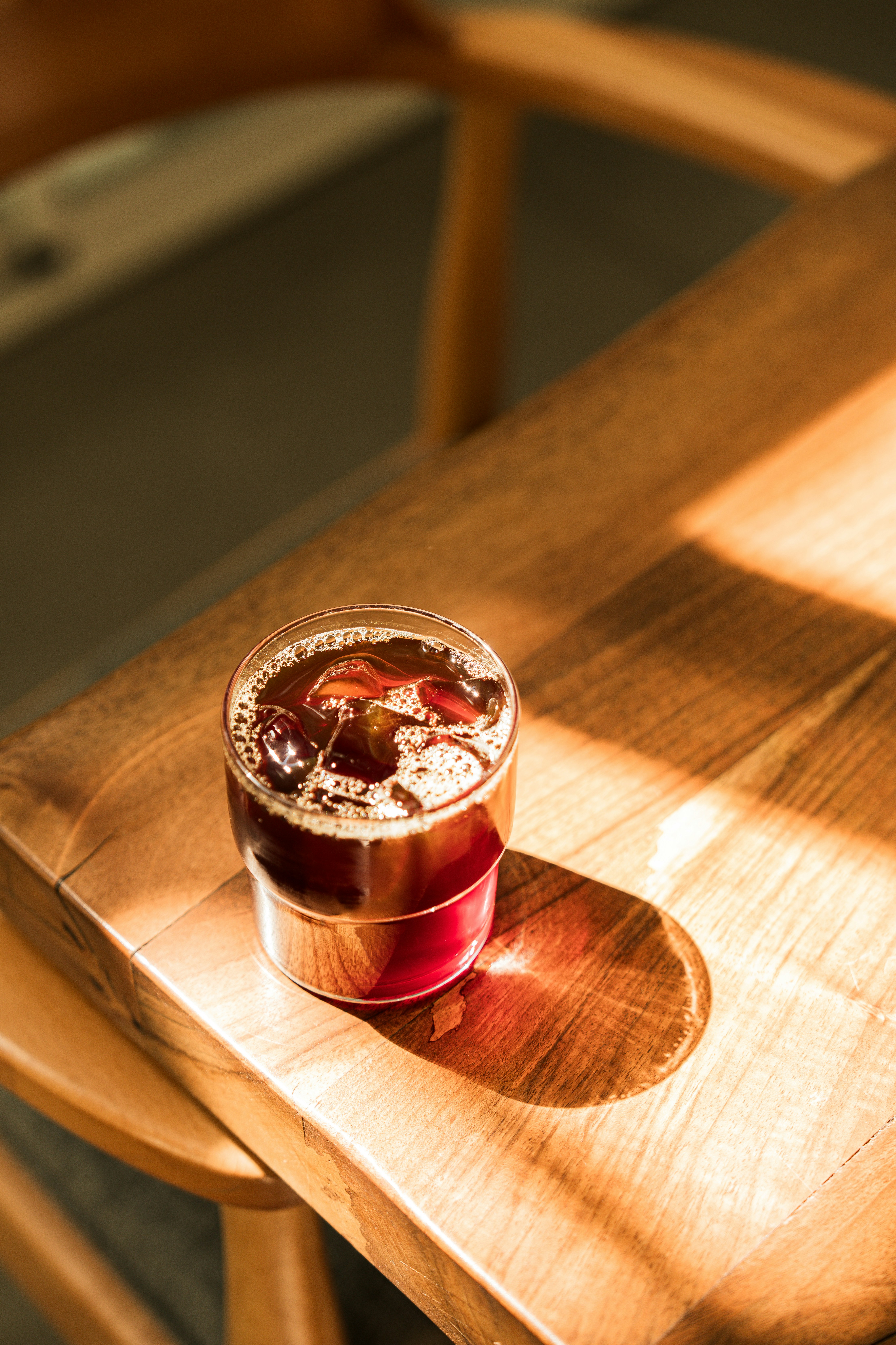 A wooden table topped with a cup of liquid