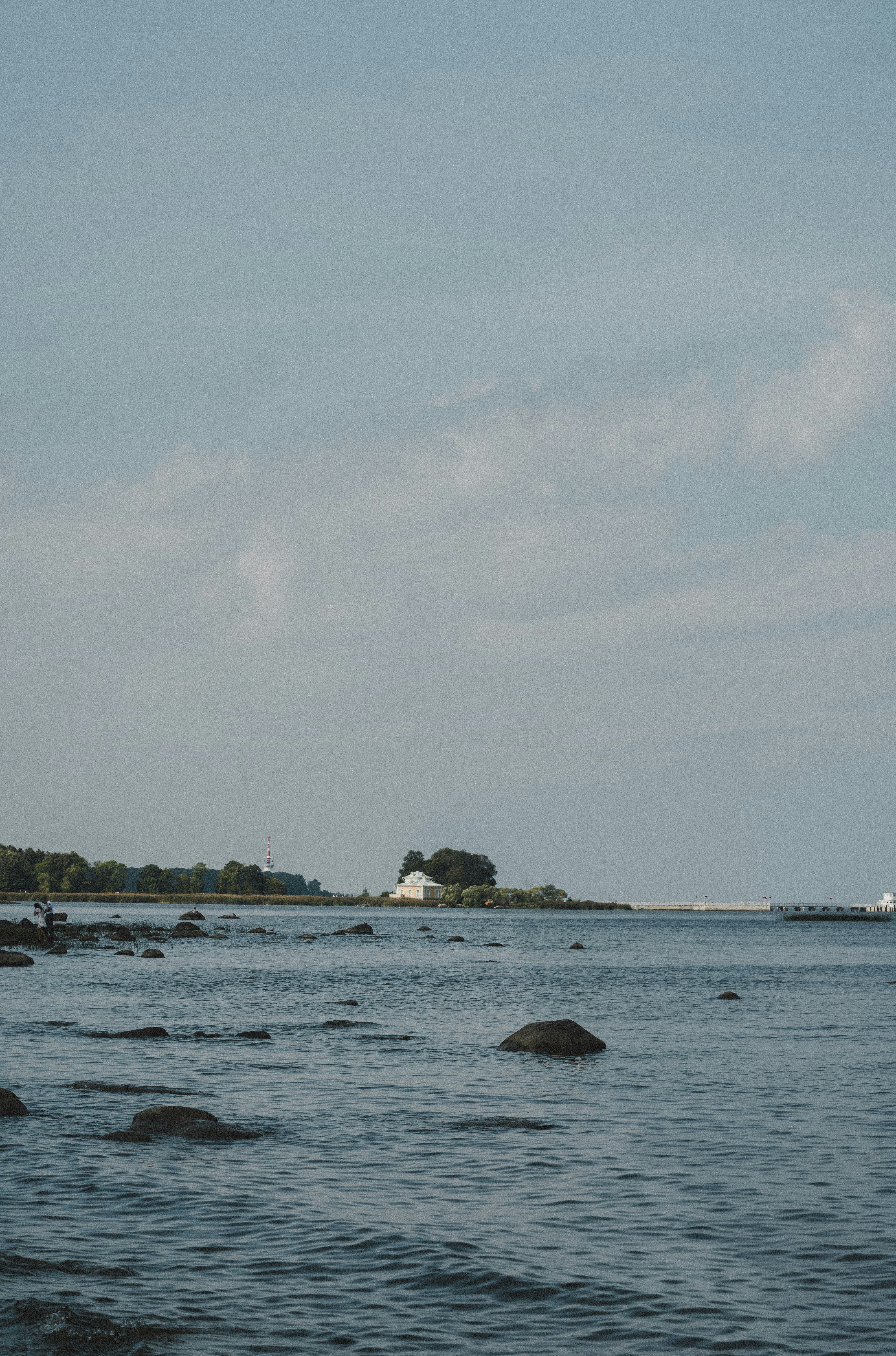 A body of water with a lighthouse in the distance